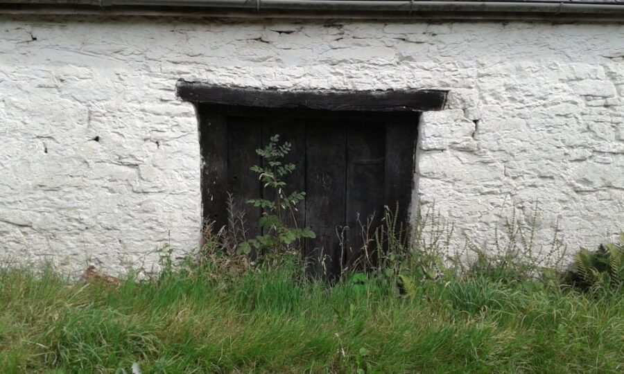 black lintel over a doorway in an old white wall
